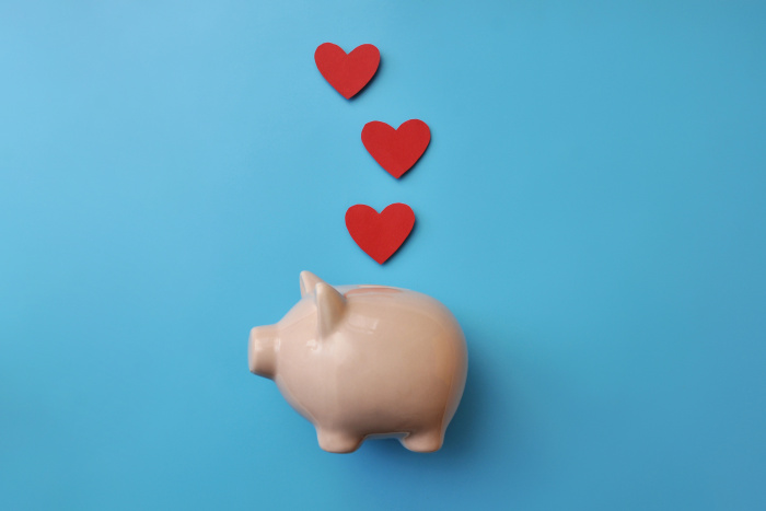 Hearts above piggy bank on blue background